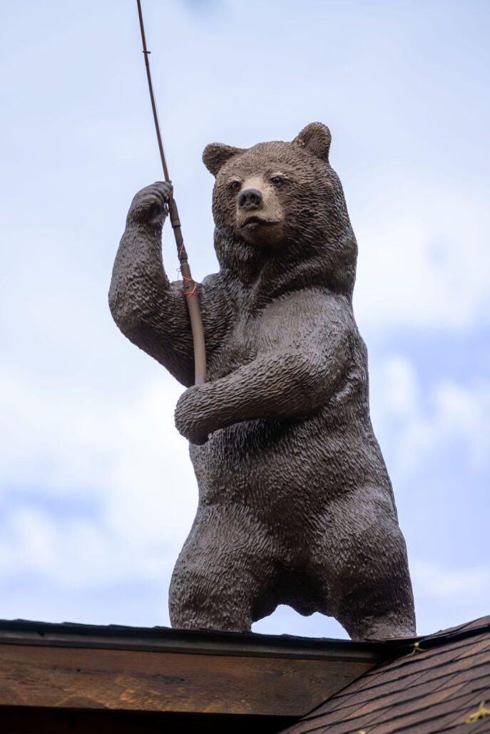 A sculpture of a standing black bear holding a fishing rod at Snake River Cabins.