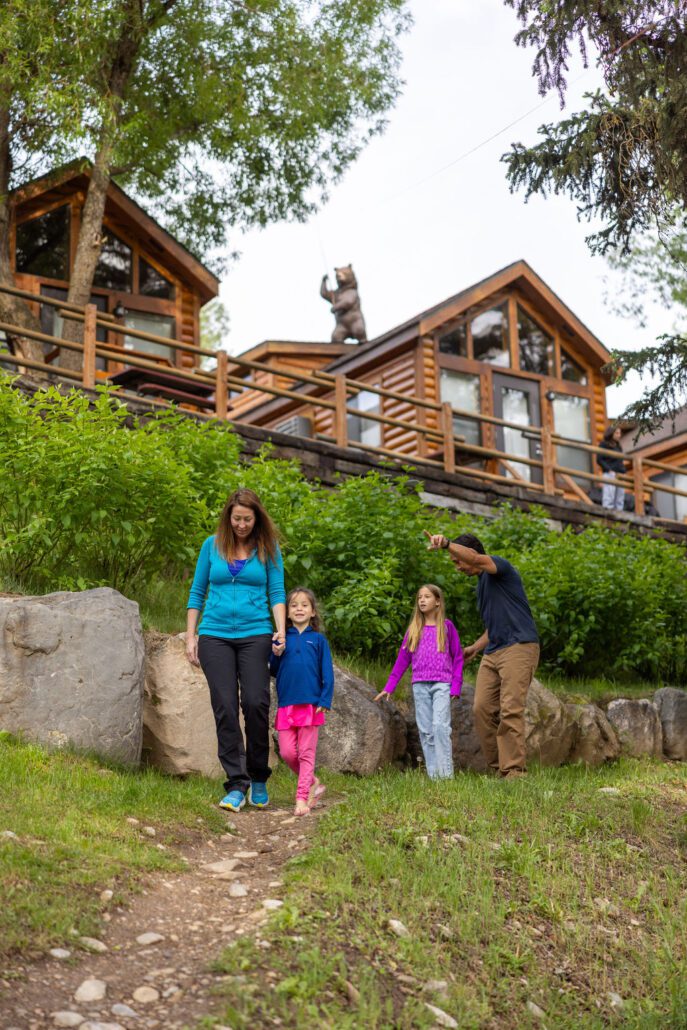 A family of four hikes down a dirt trail at Snake River Cabins.
