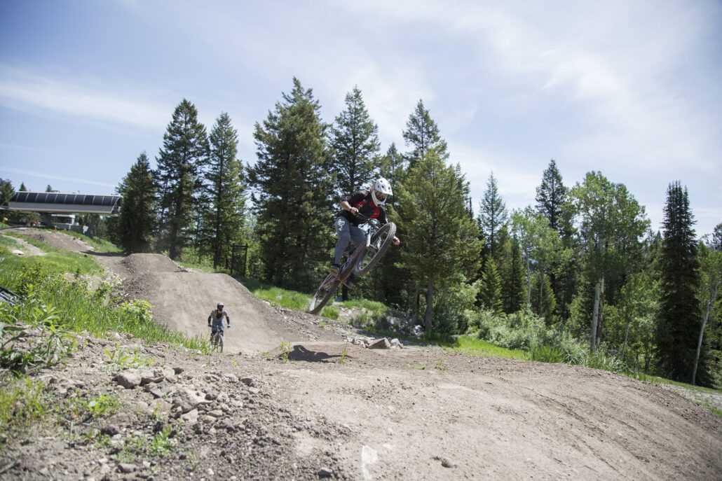 A downhill mountain biker gets air on a small jump at Jackson Hole Mountain Resort.